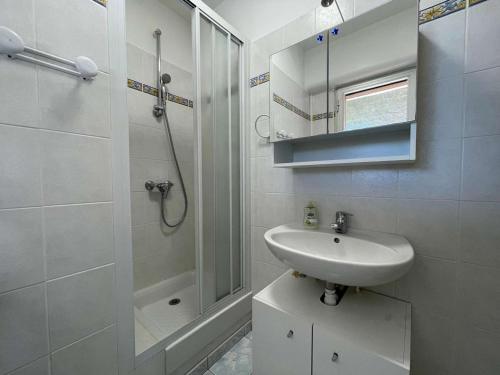 une salle de bain blanche avec un lavabo et une douche dans l'établissement Studio climatisé avec terrasse - Centre ville Le Lavandou - FR-1-308-201, au Lavandou