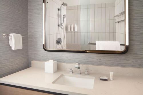 a bathroom with a sink and a mirror at Houston Marriott Sugar Land in Sugar Land