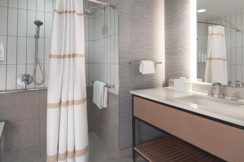 a bathroom with a sink and a shower curtain at Houston Marriott Sugar Land in Sugar Land