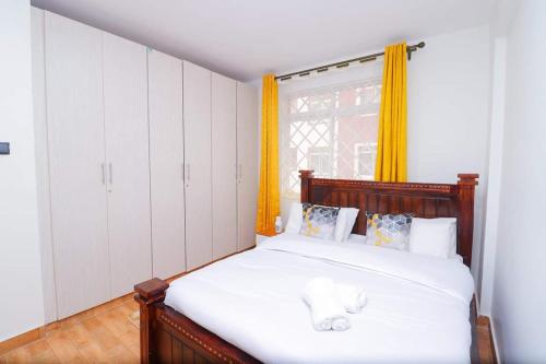 a bedroom with a bed with a teddy bear on it at The Gem-3 Bedroom Kiambu Road-Best Rated in Nairobi