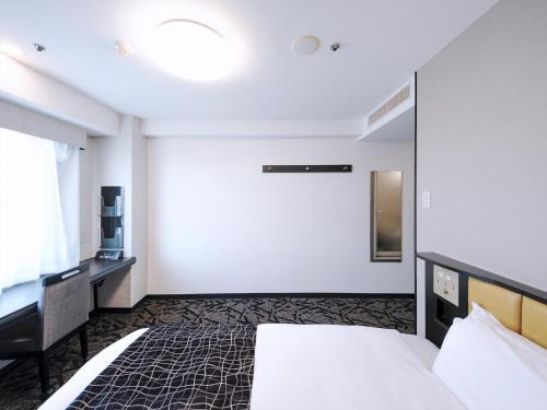a hotel room with a bed and a desk at APA Hotel Tottori Ekimae Minami in Tottori