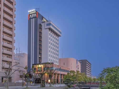 a tall building with a sign on top of it at APA Hotel Tottori Ekimae Minami in Tottori