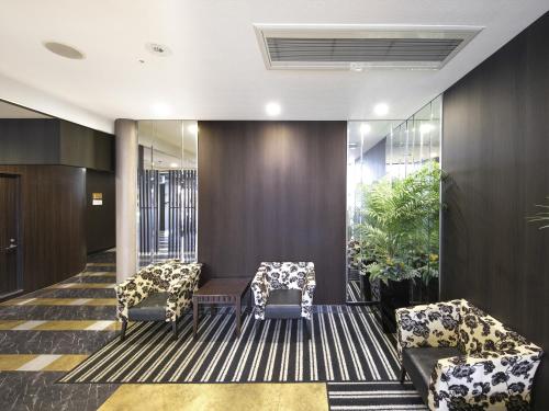 a lobby with two chairs and a table at APA Hotel Tottori Ekimae Minami in Tottori