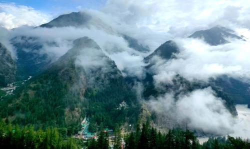 a view of a mountain covered in clouds and trees at Majestic Heights Homestay in Harsil