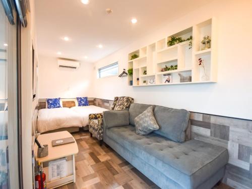 a living room with a couch and a bed at GLORY ISLAND OKINAWA Yabusachi Resort in Nanjo