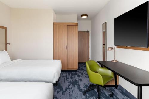 a hotel room with a desk and a bed at Fairfield by Marriott Inn & Suites Sioux Center in Sioux Center