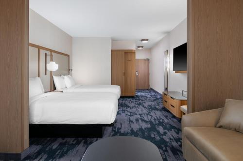 a hotel room with two beds and a couch at Fairfield by Marriott Inn & Suites Sioux Center in Sioux Center