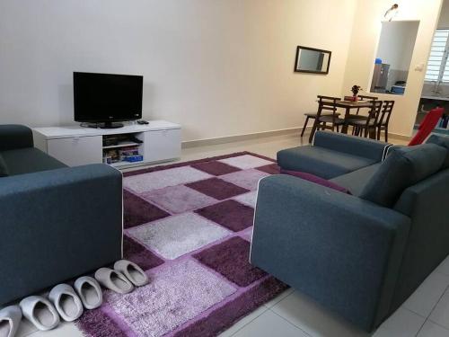 a living room with two couches and a purple rug at 4-Bedroom Homestay in Taiping, Perak in Kamunting