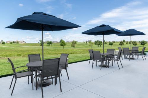 a group of tables and chairs with umbrellas at Fairfield by Marriott Inn & Suites Sioux Center in Sioux Center