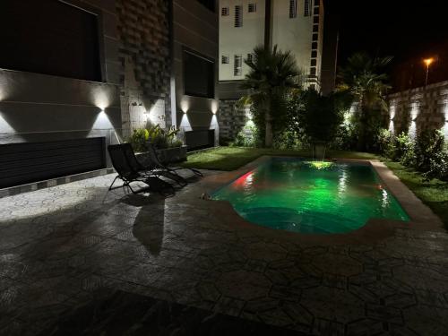 a swimming pool in the middle of a courtyard at night at Villa avec piscine oujda CGI in Oujda