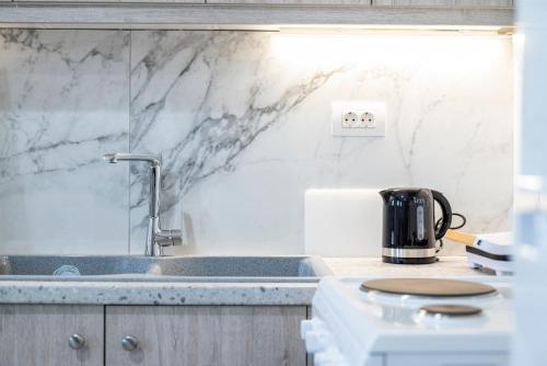 a kitchen with white marble counter tops and a sink at sunny rock 2 apartments in Lagoúdi Zía
