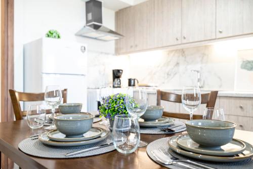 a dining room table with plates and wine glasses at sunny rock 2 apartments in Lagoúdi Zía