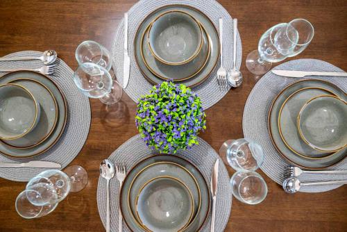 a wooden table with plates and wine glasses on it at sunny rock 2 apartments in Lagoúdi Zía