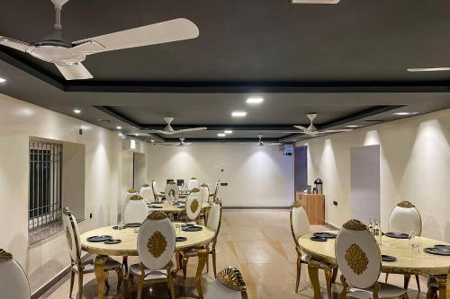 a dining room with tables and chairs and a ceiling at Super Townhouse OAK Sayhallo Ecstasy in Bhubaneshwar