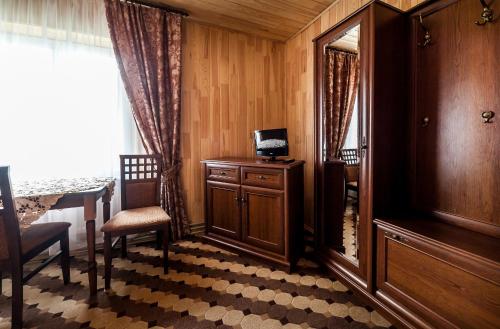 a room with a table and a chair and a mirror at Olga Hotel SPA in Tatariv