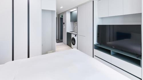 a white room with a television and a bed at Travelodge Suites Busan Centum in Busan