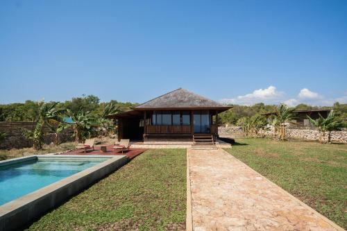 a house with a swimming pool and a building at Anna Villas by Sumba-Beach in Memboro