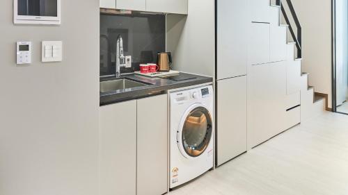 a kitchen with a washing machine and a sink at Travelodge Suites Busan Centum in Busan