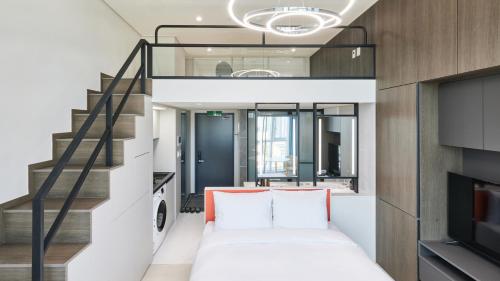 a living room with a staircase and a couch at Travelodge Suites Busan Centum in Busan