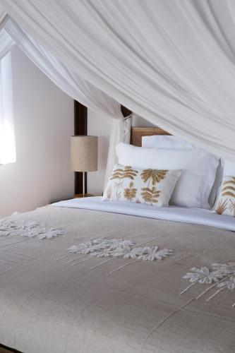 a bedroom with a bed with a white canopy at Anna Villas by Sumba-Beach in Memboro