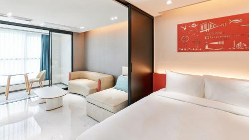 a hotel room with a bed and a chair at Travelodge Suites Busan Centum in Busan