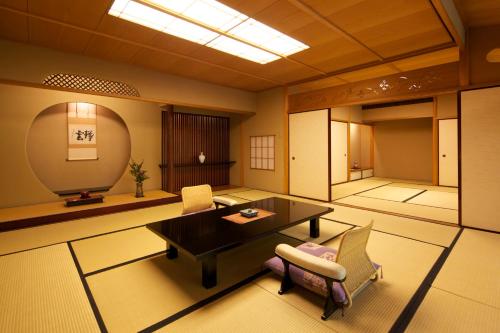 a room with a table and chairs in a room at 旅亭 半水盧 in Unzen