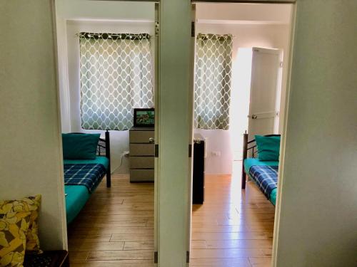 a hallway with two couches in a room with a television at Riverside 2 Bedroom 5 Beds in Naga
