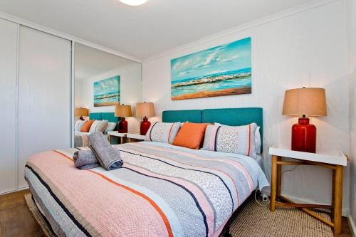 グレネルグにあるGetaway on Gordon - Comfortable stylish apartmentのベッドルーム(ベッド2台、ランプ2つ付)