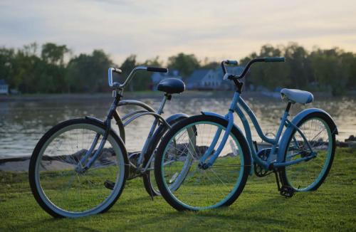 two bikes parked on the grass near the water at Eclectic Riverside Home 3 Season Room Large Deck in Moline