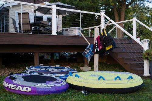 a group of inflatable boats on the grass in front of a house at Eclectic Riverside Home 3 Season Room Large Deck in Moline