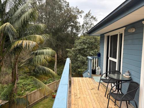 a wooden deck with a table and chairs on a house at The Gondola in Narrabeen