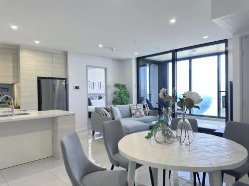 a kitchen and a living room with a table and chairs at Ocean Surfers Paradise - gclr in Gold Coast