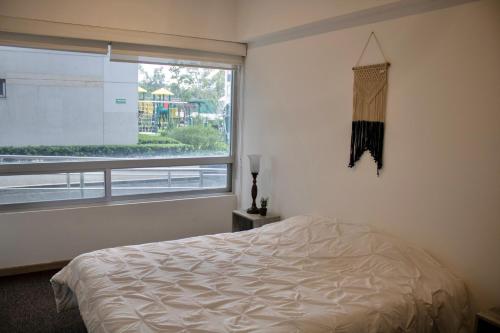 a bedroom with a bed and a large window at Condo en Zona de Hospitales Condo en Planta Baja in Mexico City