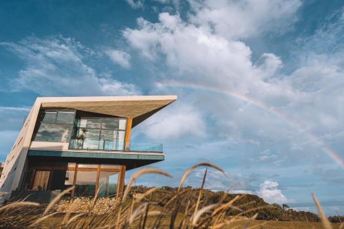 a house on top of a hill with a rainbow at Casa Ostia in Hengchun