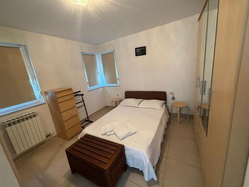 a small bedroom with a bed and a table at Apartment Vjera in Punat