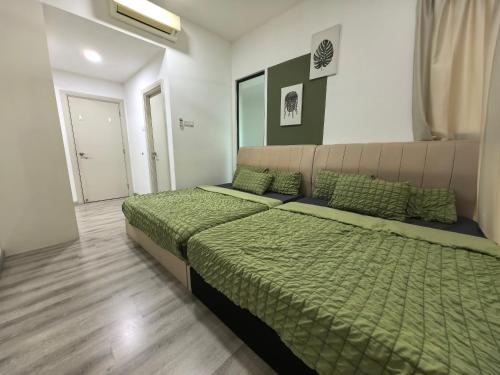 a bedroom with a large bed with green sheets and pillows at Mid Valley Southkey Mosaic Cozy Suite at Johor Bahru in Johor Bahru