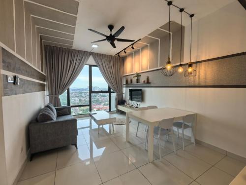 a kitchen and living room with a table and a couch at Mid Valley Southkey Mosaic Cozy Suite at Johor Bahru in Johor Bahru