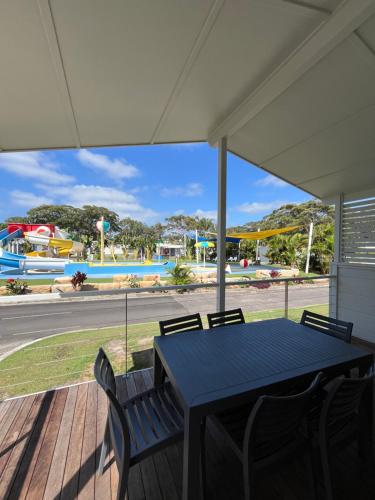 a table and chairs on a porch with a view of a pool at Shelly Beach Holiday Park in The Entrance