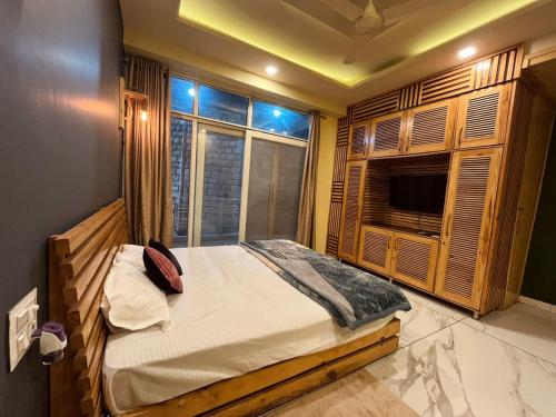 a bedroom with a large bed and a window at DIVA Nest Kasauli I Luxury Apartment IBalcony I WiFi I Open Air Roof Top Restaurant in Kasauli