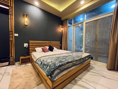 a bedroom with a bed and a large window at DIVA Nest Kasauli I Luxury Apartment IBalcony I WiFi I Open Air Roof Top Restaurant in Kasauli