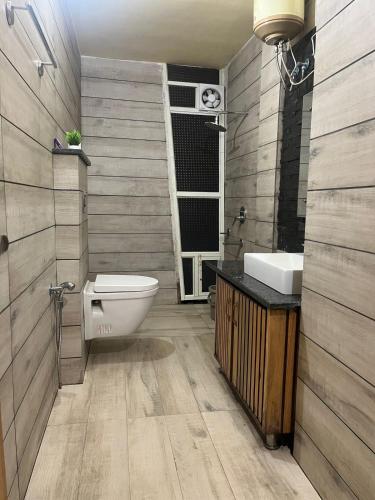 a bathroom with a toilet and a sink at DIVA Nest Kasauli I Luxury Apartment IBalcony I WiFi I Open Air Roof Top Restaurant in Kasauli