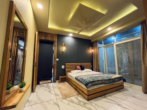 a bedroom with a bed and a large window at DIVA Nest Kasauli I Luxury Apartment IBalcony I WiFi I Open Air Roof Top Restaurant in Kasauli