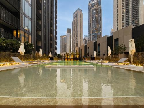 a large pool of water with umbrellas in a city at Creek Gate by Emaar, Dubai Creek Harbour in Dubai