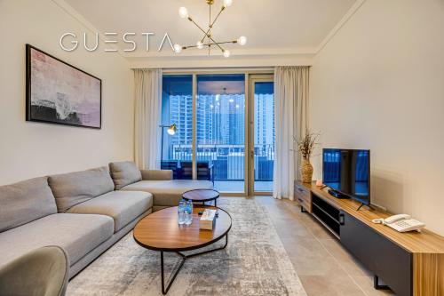 a living room with a couch and a tv at Creek Gate by Emaar, Dubai Creek Harbour in Dubai