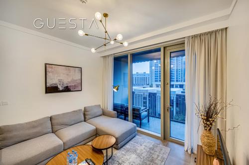 a living room with a couch and a large window at Creek Gate by Emaar, Dubai Creek Harbour in Dubai