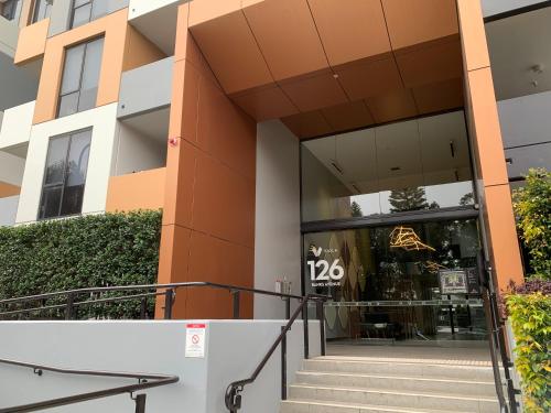 a building with the entrance to a store at Amazing 1 Bedroom Apt with Large living & extra sleeping space -up to 5 ppl Plus Gym Jacuzzi Spa Pool Sauna and Garden with BBQ in Sydney