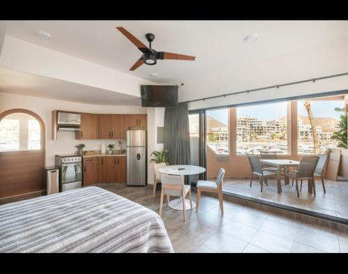 a kitchen and a living room with a ceiling fan at Marina Cabo Plaza unit 107A in Cabo San Lucas