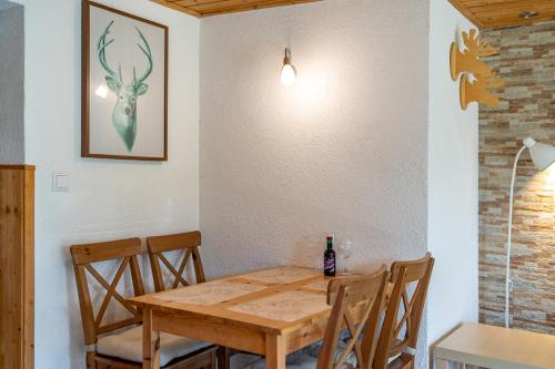a dining room table with chairs and a bottle of wine at Landhaus Danita in Bodensdorf