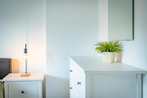 a white cabinet with a potted plant on top of it at Landhaus Danita in Bodensdorf
