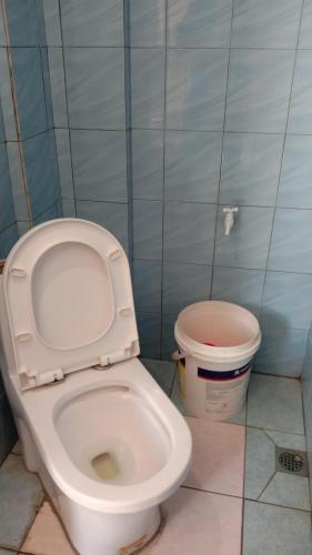 a bathroom with a toilet and a trash can at Tabin Lodge Budget Stay in Lahad Datu